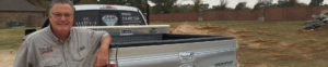 Man standing beside a pickup truck.
